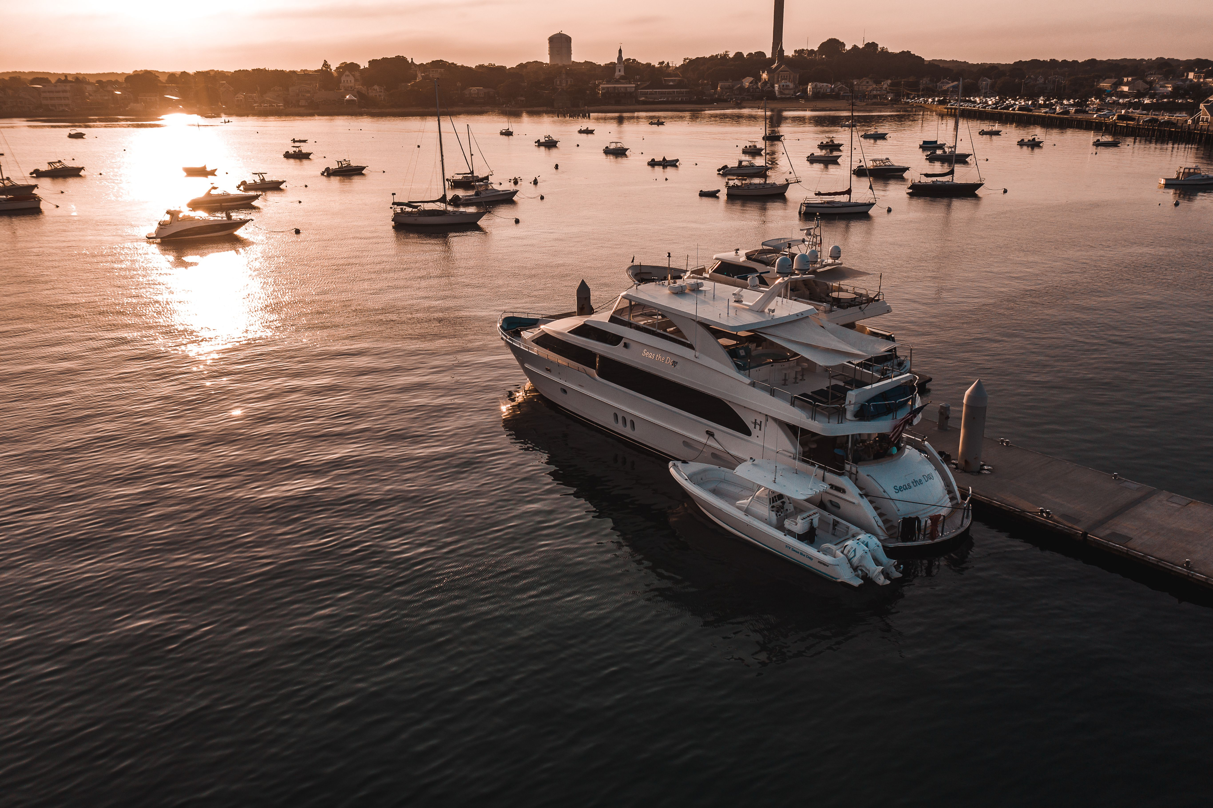 Yacht and sailboats in a harbor at sunset